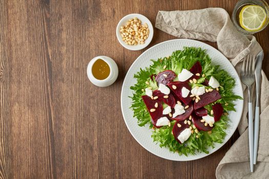 salad with beet, curd, feta, ricotta and pine nuts, lettuce. Healthy keto ketogenic dash diet, dark table, top view, copy space