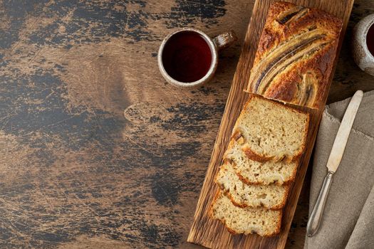 Banana bread. Cake with banana, traditional american cuisine. Slices of loaf. Dark background, black table. Copy space