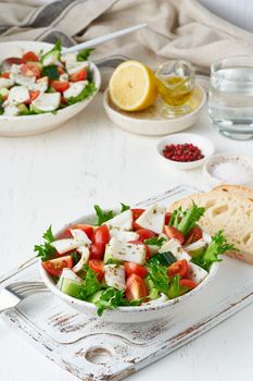 Salad with squid, cucumbers, tomatoes and lettuce. LCHF, FODMAP, paleo diet. Fresh spring vitamin mix. Healthy Mediterranean food, balanced food. Vertical, side view