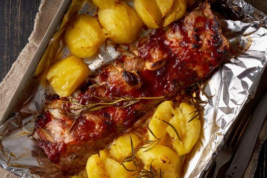 Spicy barbecue pork ribs and crushed smashed potatoes. Slow cooking recipe. Pickled Roasted Pork Meat on foil in tray