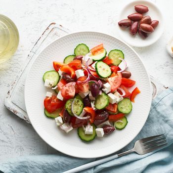 Greek village salad horiatiki with feta cheese, olives, cherry tomato, cucumber and red onion, vegeterian mediterranean food, low calories dieting meal