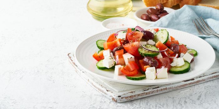 Greek village salad horiatiki with feta cheese, olives, cherry tomato, cucumber and red onion, vegeterian mediterranean food, low calories dieting meal, long banner