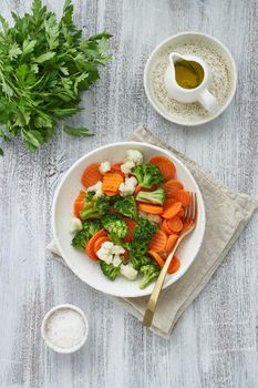 Mix of boiled vegetables. Broccoli, carrots, cauliflower. Steamed vegetables for dietary low-calorie diet. FODMAP, dash diet, vegan, vegetarian, top view, vertical