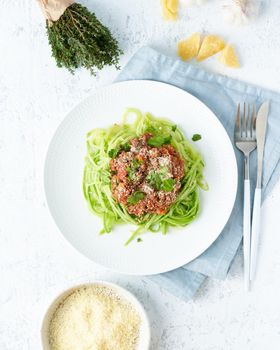 Keto pasta Bolognese with mincemeat and zucchini noodles, fodmap, lchf, low carb, ketogenic diet. Top view, close up, vertical. Clean eating, balanced food.