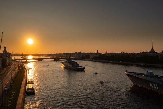 Aerial morning urban landscape with warships in the waters of the Neva River before the holiday of the Russian Navy, sea power, the latest cruisers among the sights, Isaac cathedral on a background. High quality photo