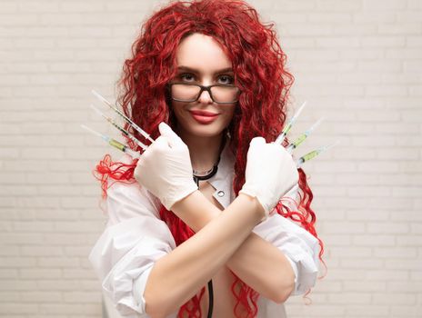 the sexy portrait of a nurse girl with vaccination syringes in her hands