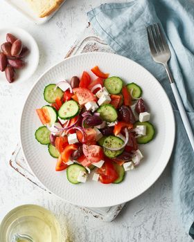 Greek village salad horiatiki with feta cheese, olives, cherry tomato, cucumber and red onion, vegeterian mediterranean food, low calories dieting meal, vertical