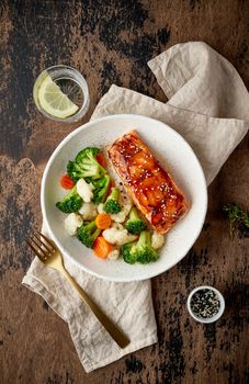 Steam salmon and vegetables, Paleo, keto, fodmap, dash diet. Mediterranean food with steamed fish. Oven baked asian dish with teriyaki. Healthy concept, gluten free, lectine free, top view, vertical