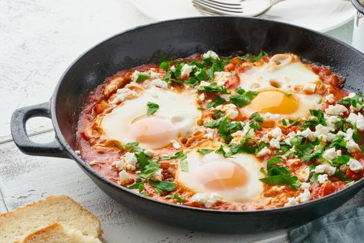 Shakshouka, eggs poached in sauce of tomatoes, olive oil, peppers, onion and garlic, Mediterranean cuisine. Keto meal, FODMAP recipe, low carb. Side view, close up