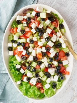 Greek salad Horiatiki with feta cheese, olives, tomato, cucumber, lettuce, vegeterian mediterranean food, low calories dieting meal, vertical