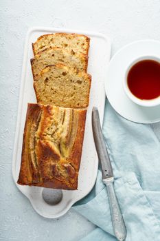 Banana bread. Cake with banana, traditional american cuisine. Slice of loaf. Gray background. Top view