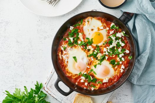 Shakshouka, eggs poached in sauce of tomatoes, olive oil, peppers, onion and garlic, Mediterranean cousine. Keto meal, FODMAP recipe, low carb. Top view, copy space