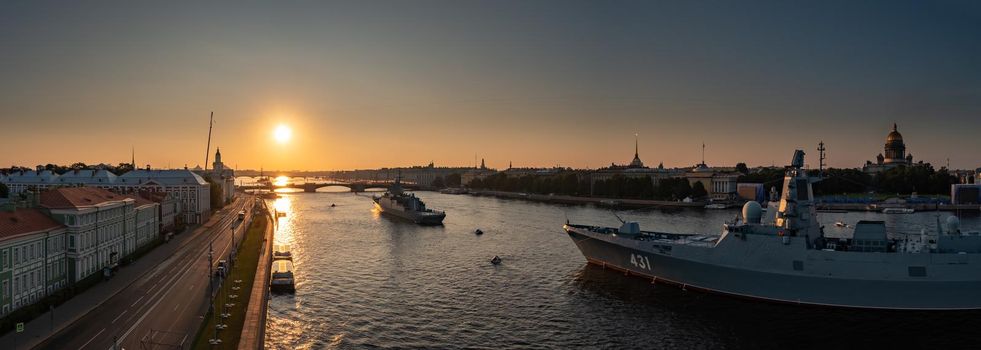 Aerial panoramic landscape of warships in the waters of the Neva River before the holiday of the Russian Navy, sea power, the latest cruisers among the sights, Isaac cathedral on a background. High quality photo