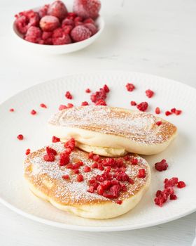 Fluffy japanese pancake, thick souffle. Trendy food. Delicious Breakfast on a white background. Side view, vertical