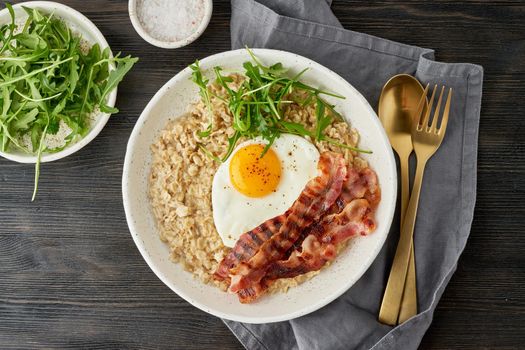 Oatmeal, fried egg and fried bacon. Brutal man sport breakfast. Hearty fat high-calorie breakfast, source of energy. Balance of proteins, fats, carbohydrates. Balanced food. Close up