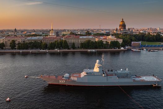 Aerial morning urban landscape with warships in the waters of the Neva River before the holiday of the Russian Navy, sea power, the latest cruisers among the sights, Isaac cathedral on a background. High quality photo