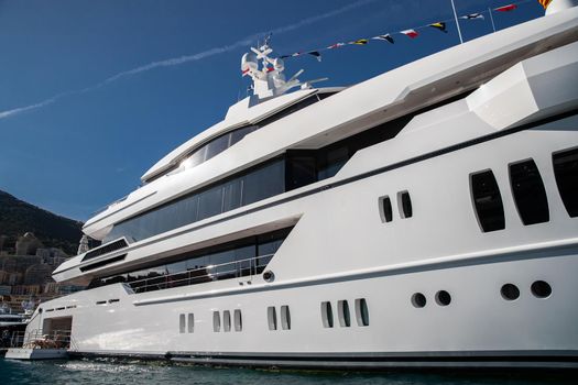 The top deck of a huge yacht at sunny day, glossy board of the boat, The chrome plated handrail, megayacht is moored in port, sun reflection on glossy board. High quality photo
