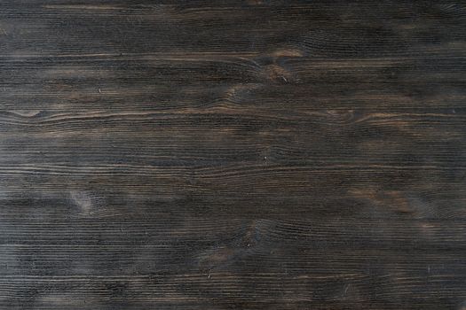 Dark black brown texture wooden background pattern. Texture of natural wood, pine rustic hardwood, closeup, top view. Wooden backdrop, table. Copy space
