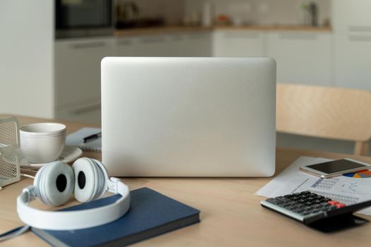 Freelance desk with laptop in kitchen room. Work from home. Distance education. Online learning, teleworking and online lectures. Concept of digital nomads, blogging.