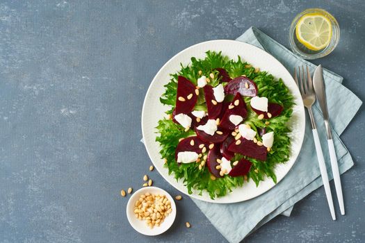 salad with beet, curd, feta, ricotta and pine nuts, lettuce. Healthy keto ketogenic dash diet, dark table, top view, copy space