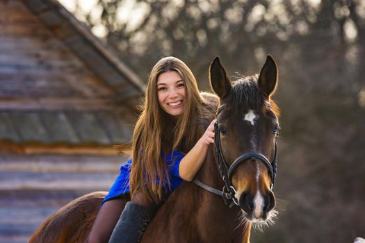 Girl in a blue dress on a beautiful horse a