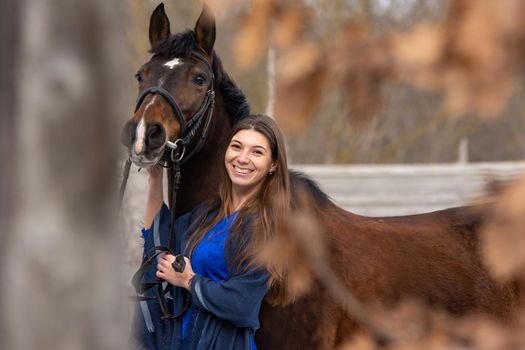 Portrait of a happy beautiful girl of Slavic appearance and a horse a