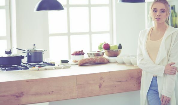 Young woman standing near desk in the kitchen