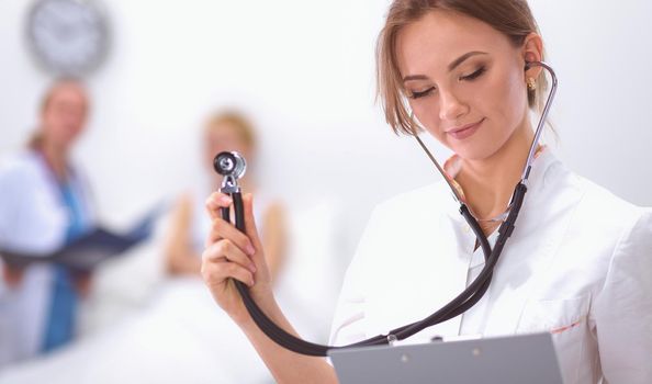 Portrait of woman doctor standing with folder at hospital
