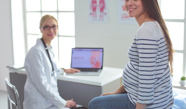 Beautiful smiling pregnant woman with the doctor at hospital.