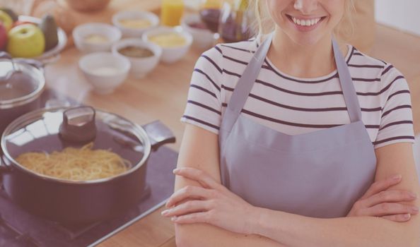 Young woman standing near desk in the kitchen .