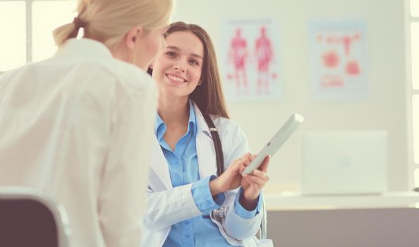 Doctor and patient discussing something while sitting at the table . Medicine and health care concept.