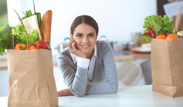Portrait of a smiling woman cooking in her kitchen sitting.