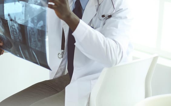 Portrait young african medical doctor holding patient's x-ray.
