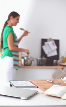 Woman making healthy food standing smiling in kitchen.