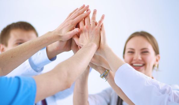 Doctors and nurses in a medical team stacking hands .