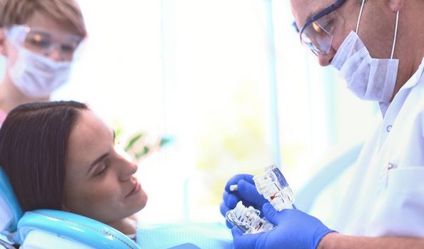 Beautiful senior woman at dentist having dental treatment at dentist's office.