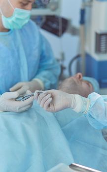 Man surgeon at work in operating room.