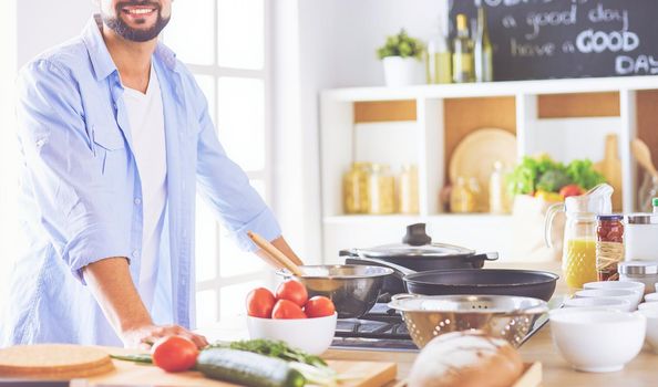 Man preparing delicious and healthy food in the home kitchen.