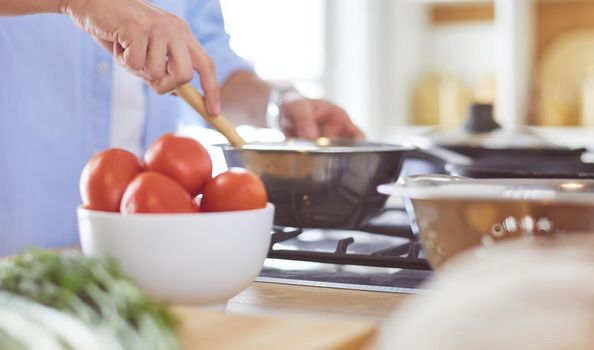 Man preparing delicious and healthy food in the home kitchen.