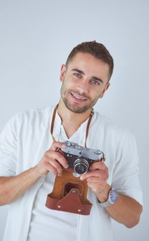 Young man with camera. Isolated over white background