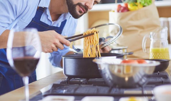 Man preparing delicious and healthy food in the home kitchen.
