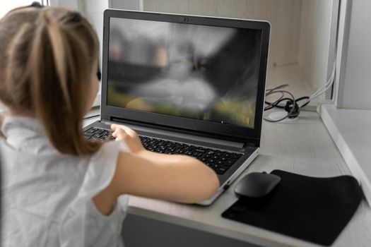 cute little caucasian girl studying online at home