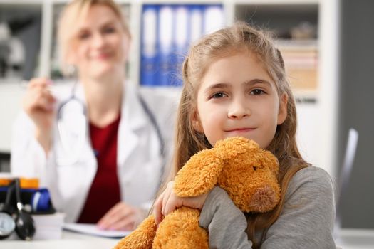 Portrait of cute smiling child at pediatrician, kid hug teddy bear favourite toy. Healthy lifestyle, sickness, clinic test, childhood, diagnostic concept