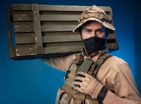 army soldier in military clothes with a box of ammunition on his shoulder