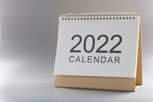 Close-up of 2022 new year calendar, time for change of time, focus on upcoming year. 2022 paper calendar on grey surface. New year, future, planner concept