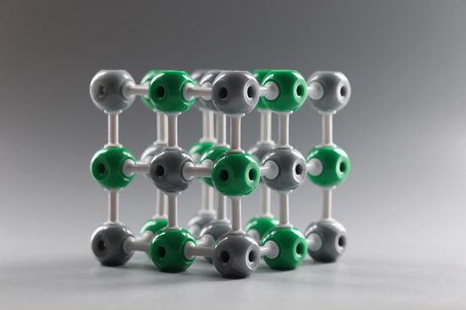 Close-up of molecular dna model structure on grey background, grey and green cells connected to each other. Laboratory, chemistry, investigation concept