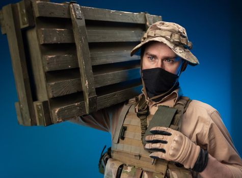 army soldier in military clothes with a box of ammunition on his shoulder