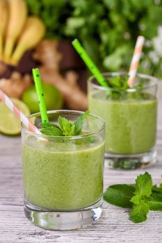 Fresh organic detox green drink smoothie with celery, spinach, banana, cilantro, lime and ginger with refreshing mint. Healthy, dietary, vegetarian food