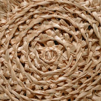 Circular pattern of woven seagrass basket. Abstract background - natural rattan or sea grass in circular woven. Minimalistic simple beige rustic and natural pattern background