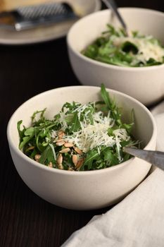 Arugula salad with sunflower kernels and sprinkled with grated parmesan